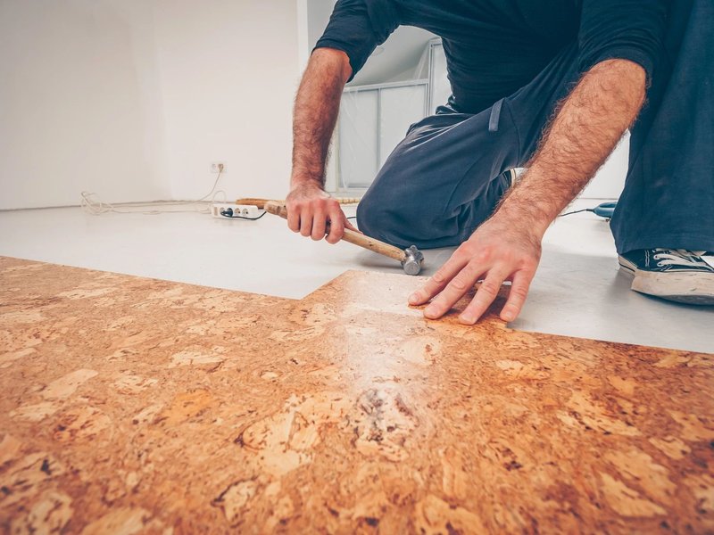 Person installing cork flooring from Capitol Carpet in Dalton, GA