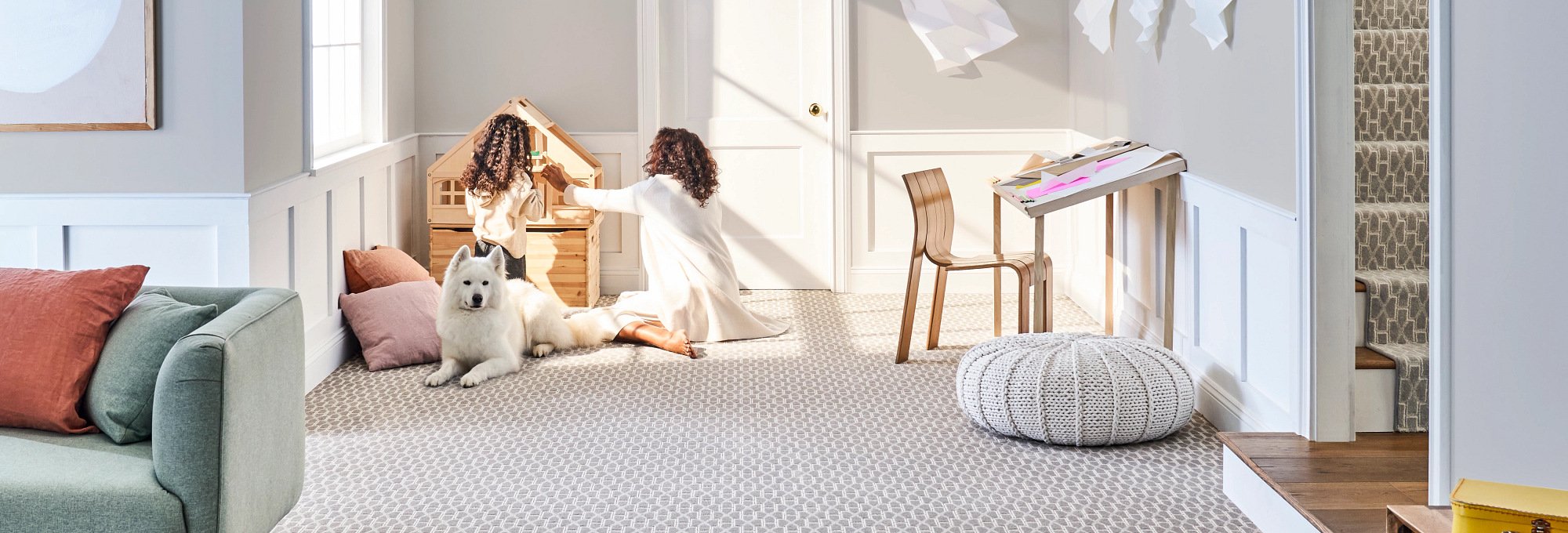 People in a room with a dog and beige textured carpet from Capitol Carpet in Dalton, GA